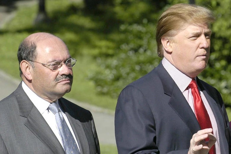 Weisselberg, a shorter bald man with a mustache, stands next to Trump while Trump gestures.